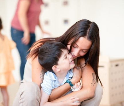 Une professionnelle de crèche fait un câlin à un enfant