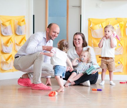 Un papa et son enfant, avec un professionnel de crèche en crèche