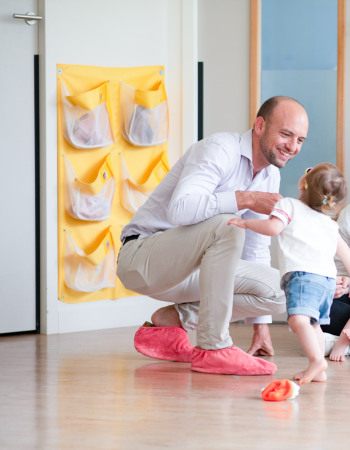 Un parent, une professionnelle et des enfants discutent en crèche Babilou