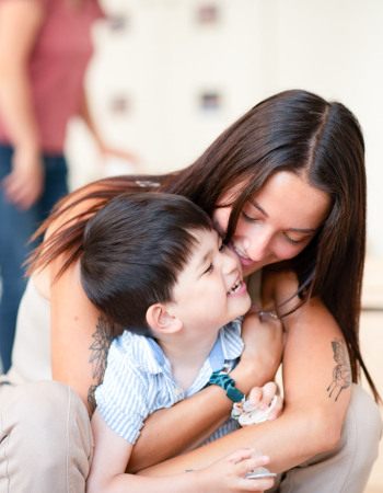Une professionnelle de crèche fait un câlin à un enfant