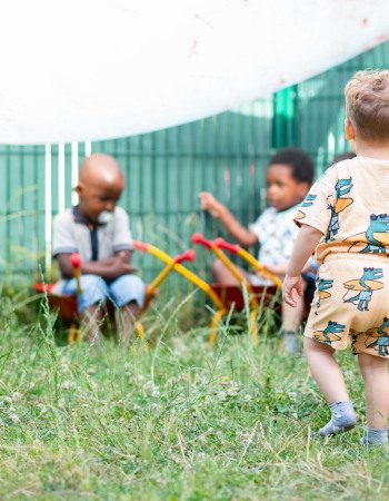 Trois enfants en train de jouer dans le jardin d'une crèche Babilou