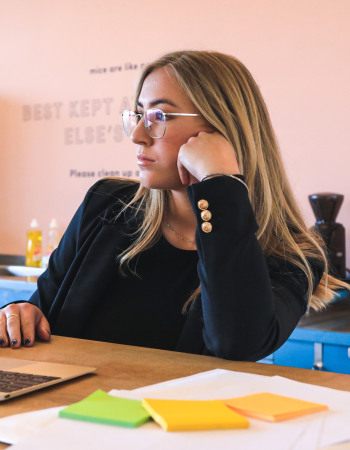 Jeune fille pensive, travaillant à domicile, devant son ordinateur portable