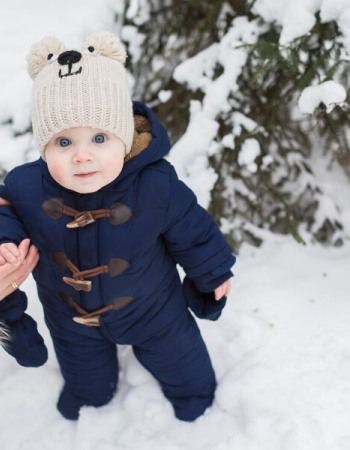 Bébé debout sur de la neige 