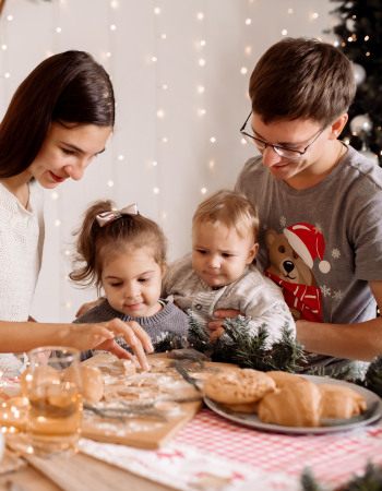Photo d'une famille à noël en train de faire de la patisserie 