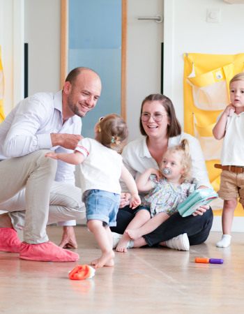 Un papa et son enfant, avec un professionnel de crèche en crèche
