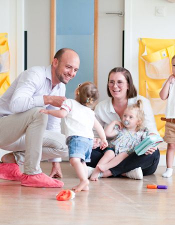 Un papa et son enfant, avec un professionnel de crèche en crèche