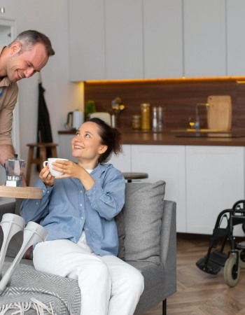 Un homme apportant un café à une femme avec deux béquilles 