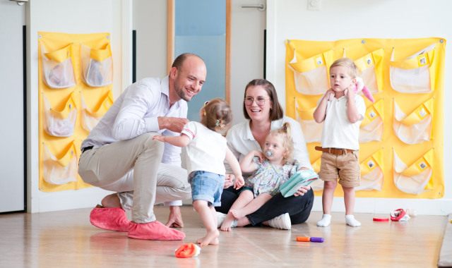 Un parent, une professionnelle et des enfants discutent en crèche Babilou
