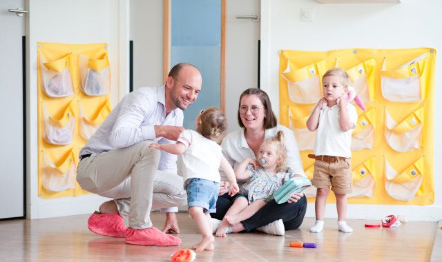 Un parent, une professionnelle et des enfants discutent en crèche Babilou