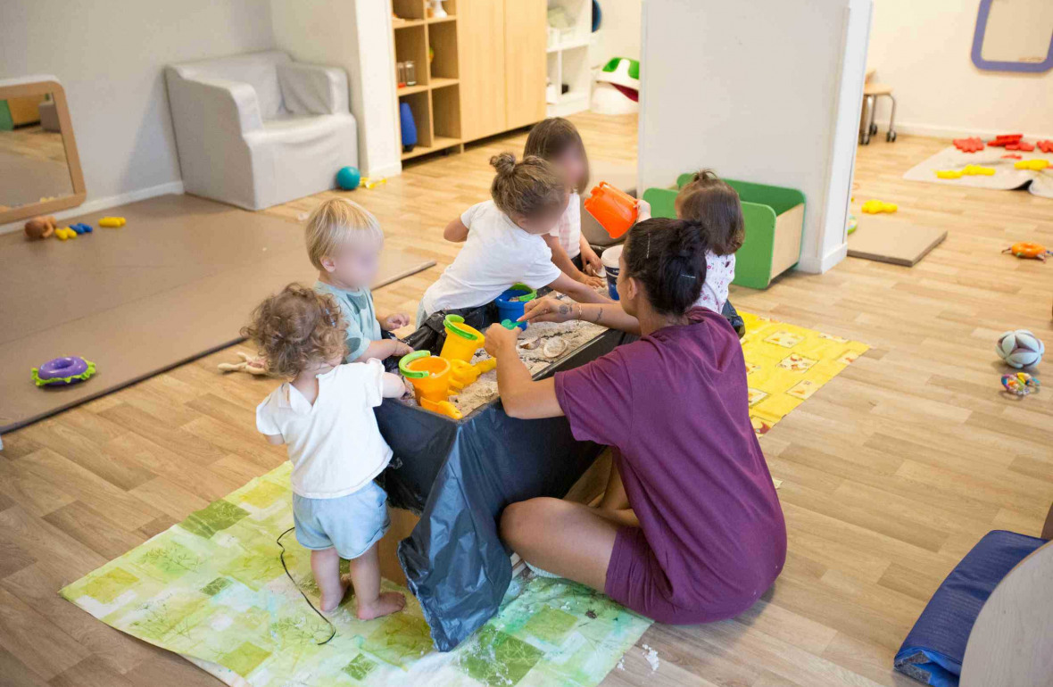 Un groupe d'enfant en crèche durant une activité accompagné d'une professionnelle 