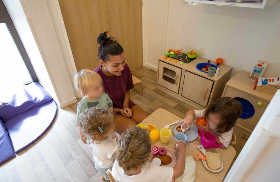 Une professionnelle en crèche Babilou avec un groupe d'enfant 