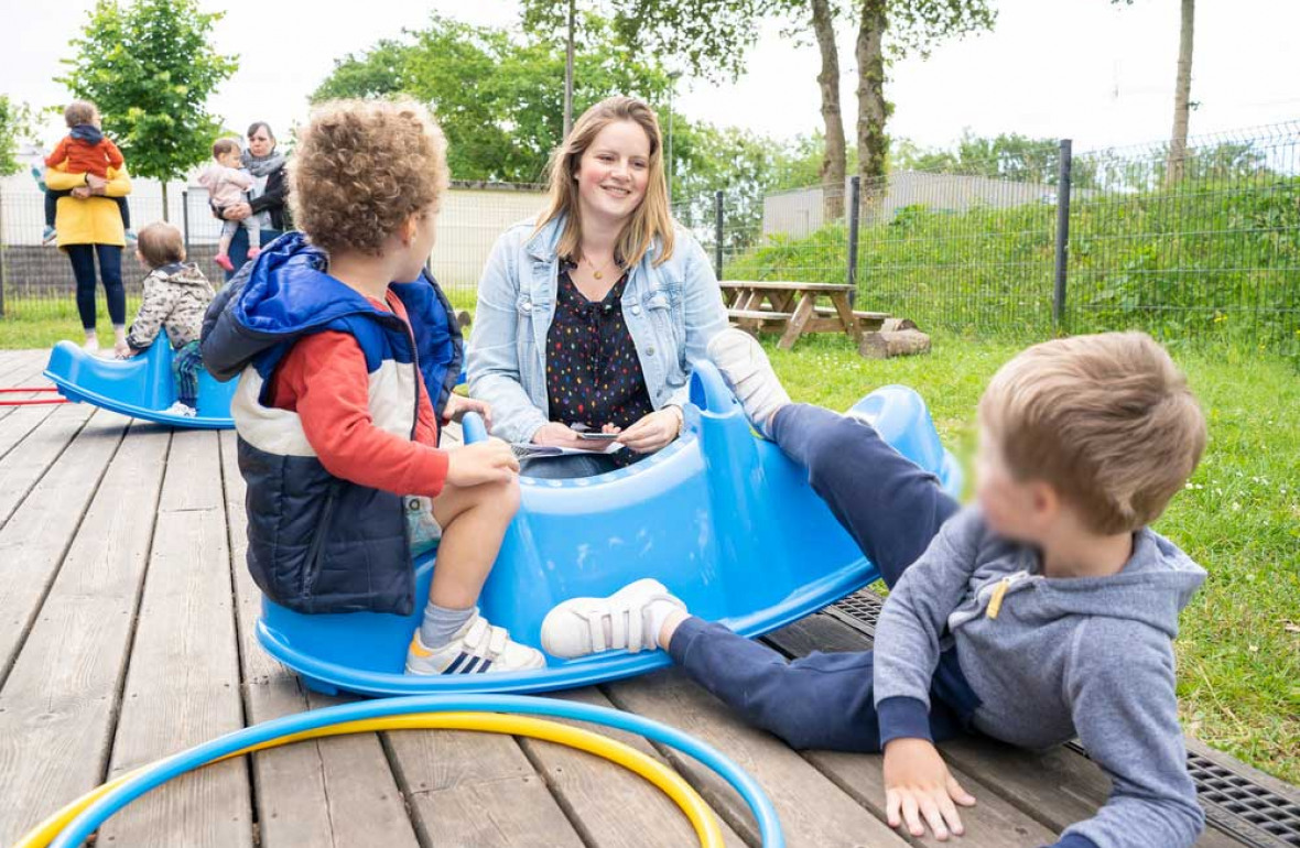 Enfants et professionnelle jouant ensemble dehors au sein de la creche Babilou Chateaubourg Cugnot