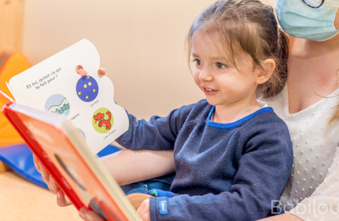 Une petite fille et une professionnelle qui lit un livre 