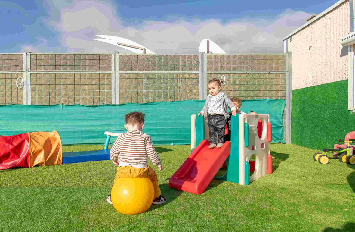 Un groupe d'enfants qui joue dans le jardin de la crèche 