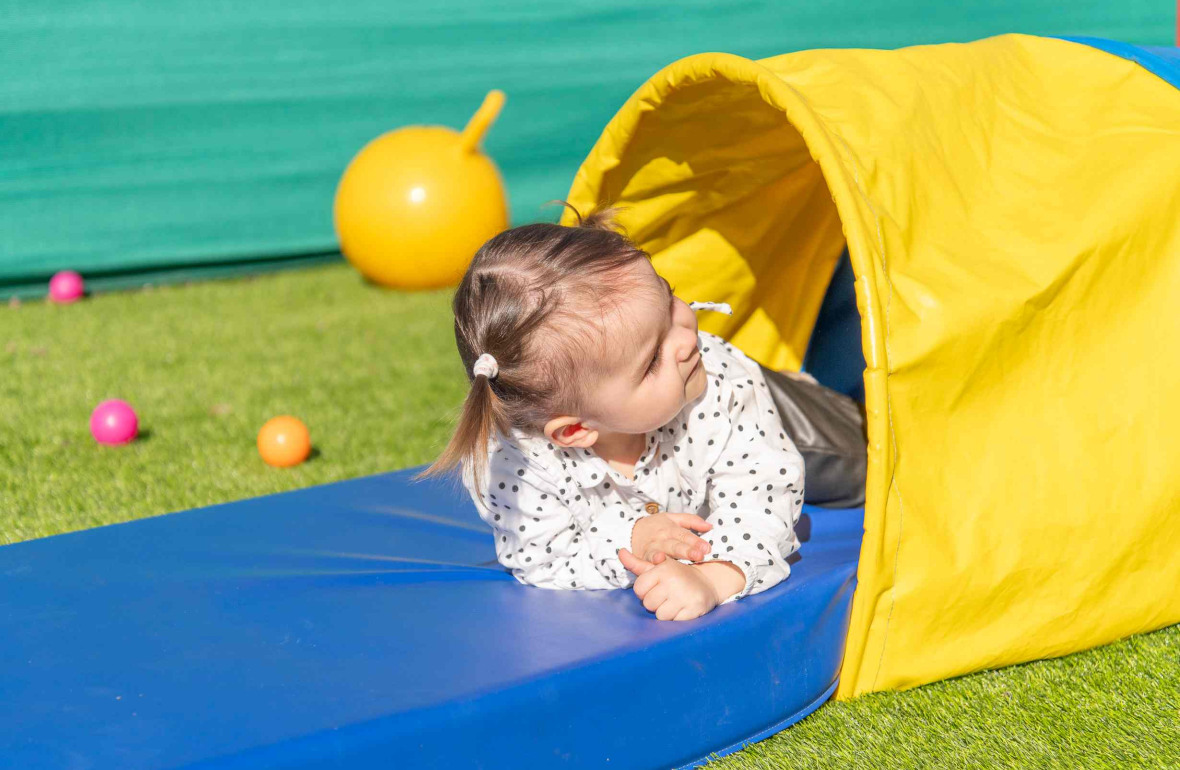 Une petite fille en crèche qui joue dans le jardin 