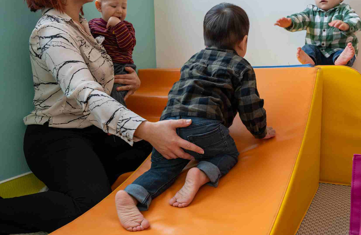 Une pro en crèche qui joue avec un groupe d'enfants