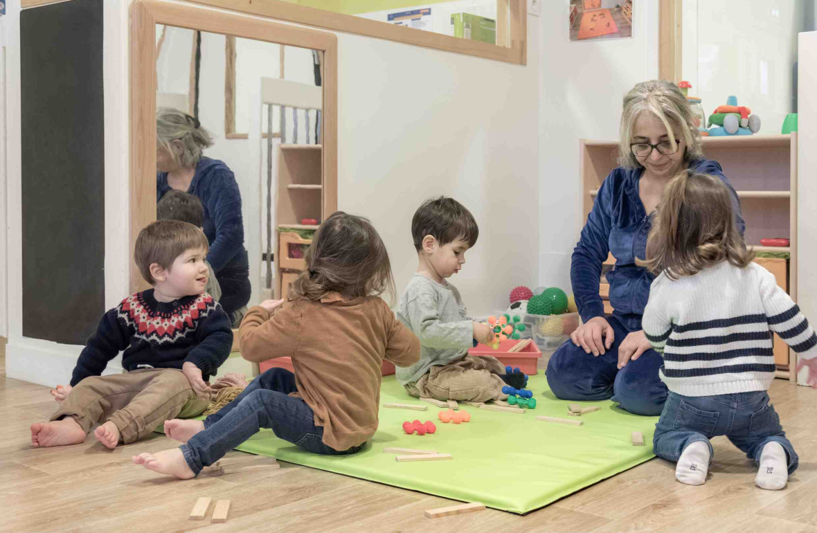 Une pro en crèche jouant avec un groupe d'enfants