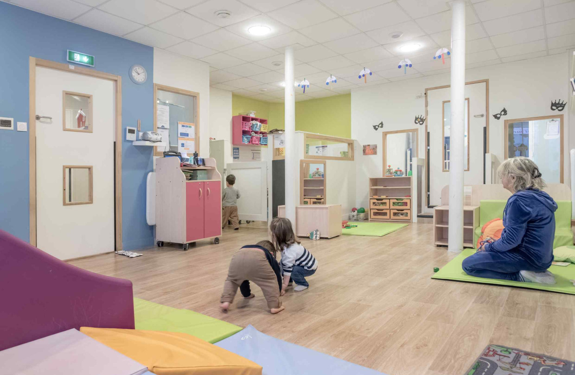 Une pro en crèche en interaction avec deux enfants 