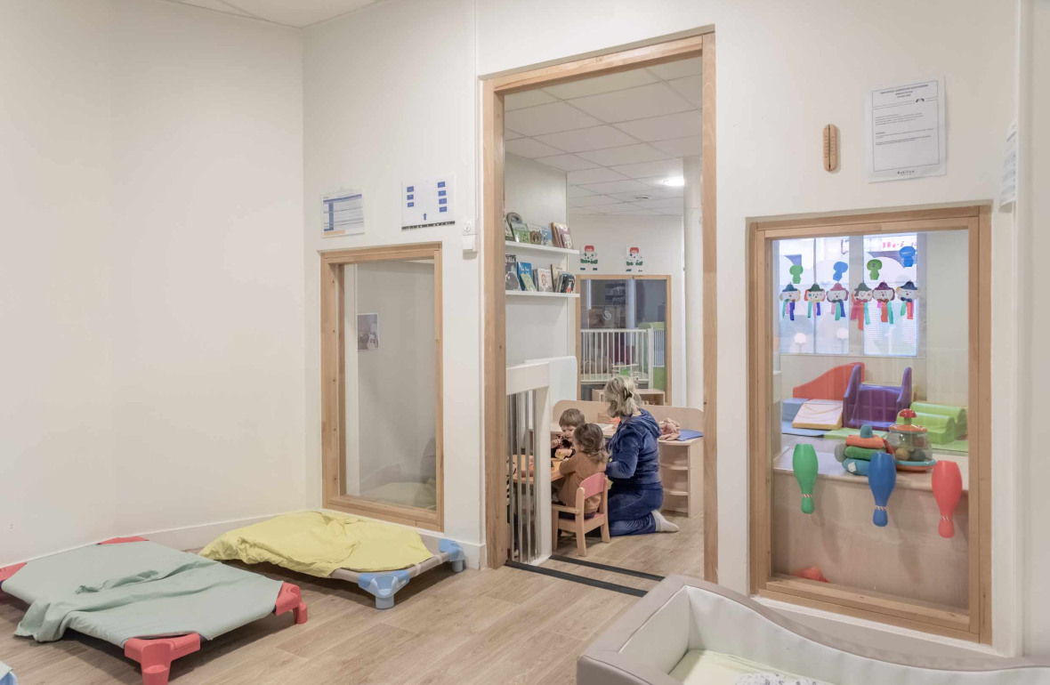 Une pro en crèche en interaction avec deux enfants 