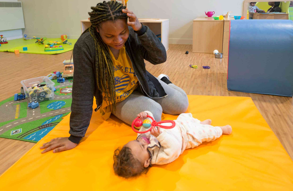 Une pro en crèche qui joue avec un bébé