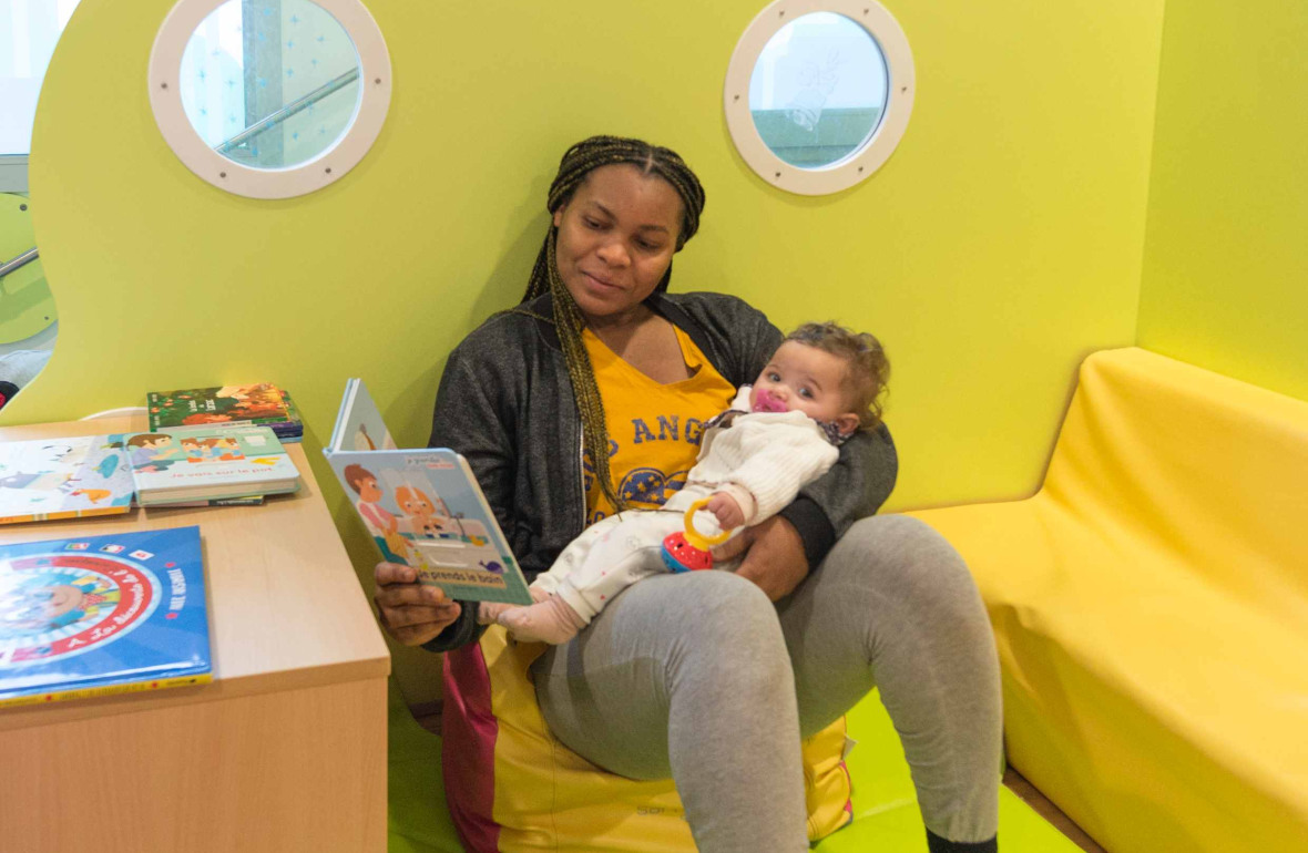 Une pro en crèche qui lit un livre à un enfant