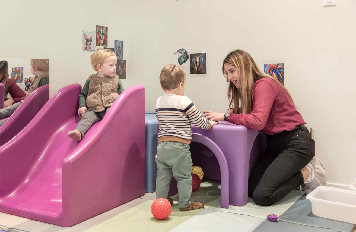 Une pro en crèche jouant avec deux enfants 