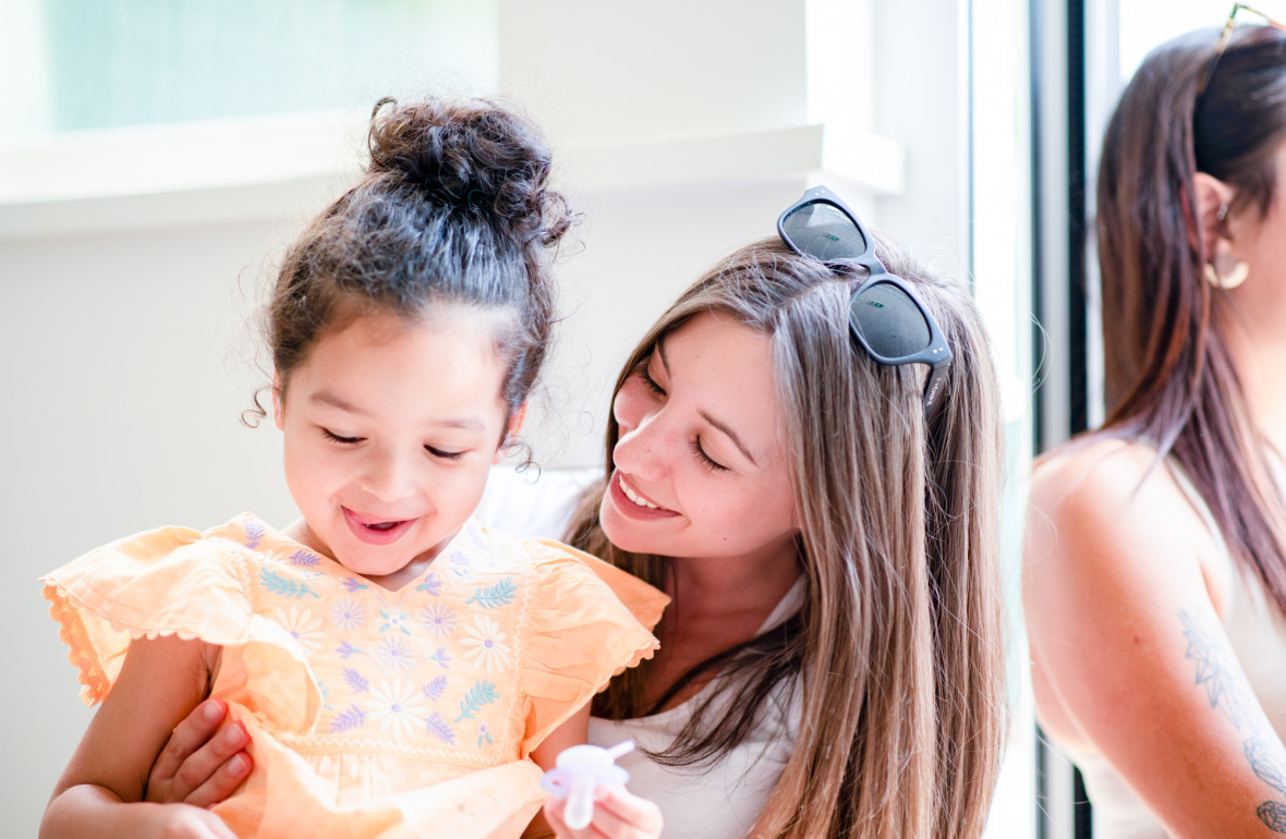 Professionnelle en crèche rigolant avec une petite fille