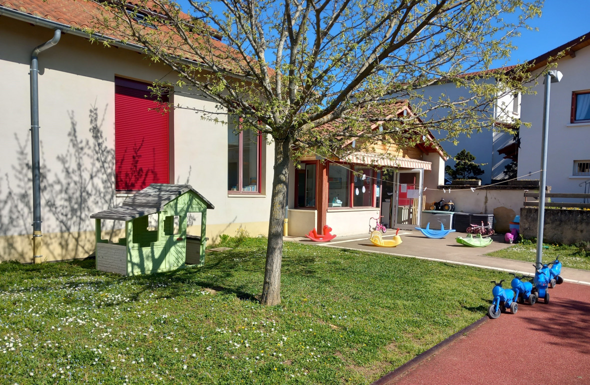 Pelouse et tricycles dans le jardin de la micro-crèche Babilou Eveux Eglise