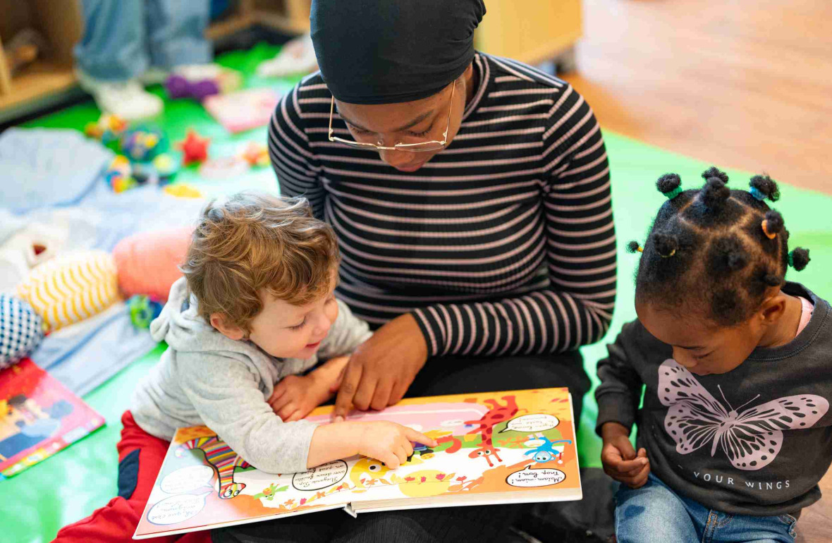 Une pro en crèche qui lit un livre à des enfants