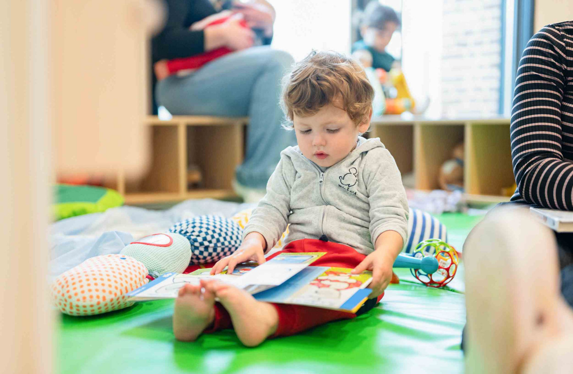 Un enfant qui lit un livre en crèche 