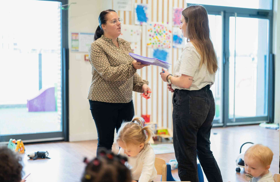 Deux pros avec un groupe d'enfants en crèche