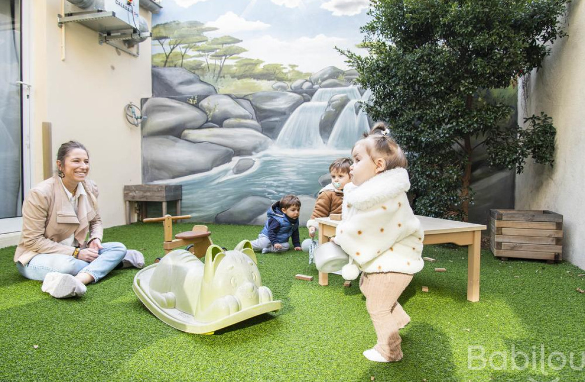 Une pro en crèche dans le jardin avec une enfant