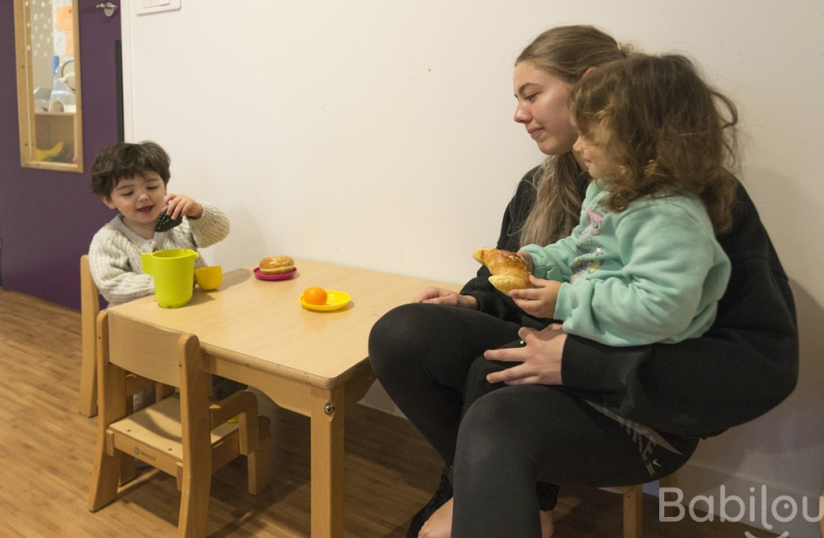 Une pro en crèche jouant avec deux enfants 