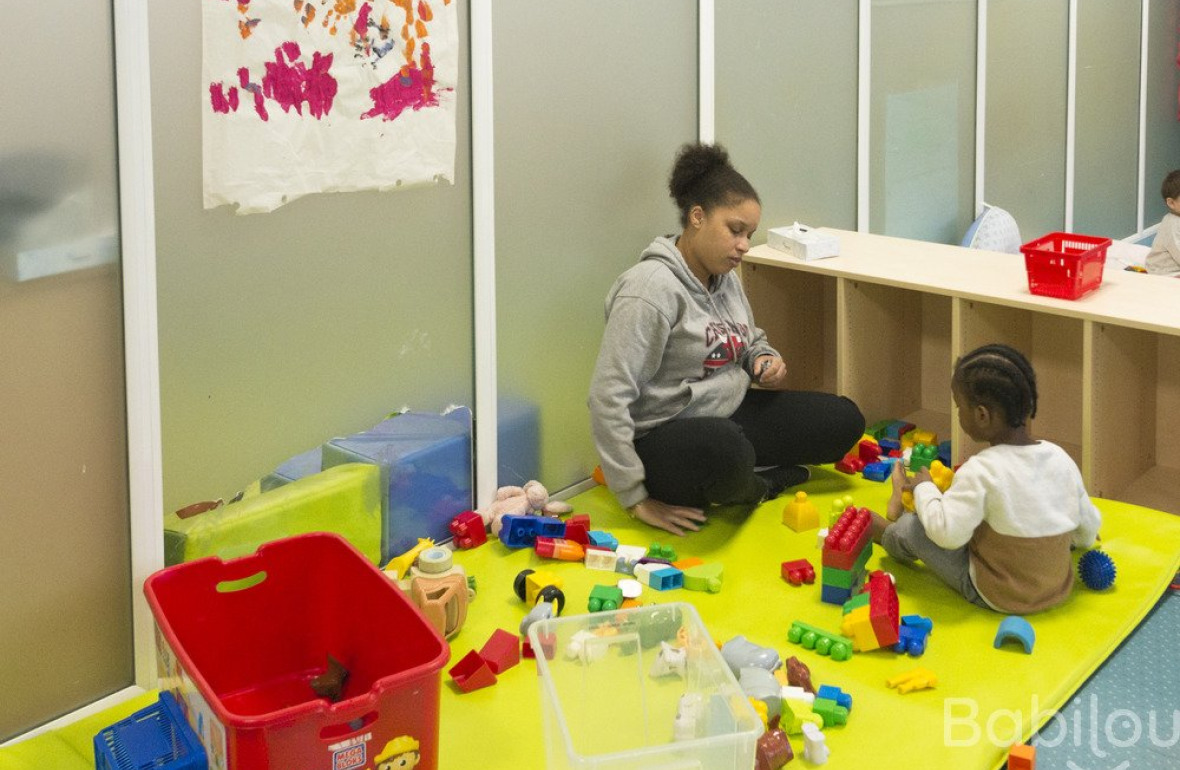 Une pro en crèche qui joue avec un enfant
