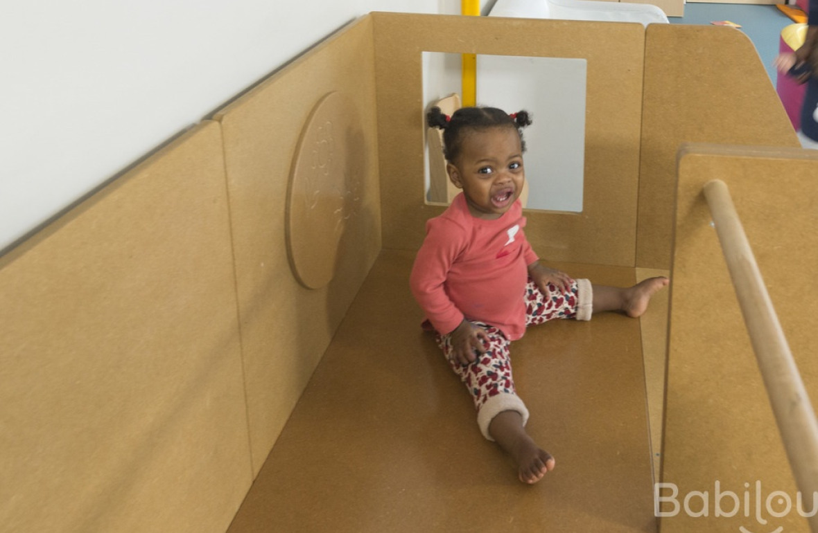 Une enfant en crèche Babilou assise 