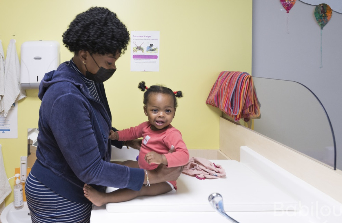 Une professionnelle en crèche Babilou qui change une enfant