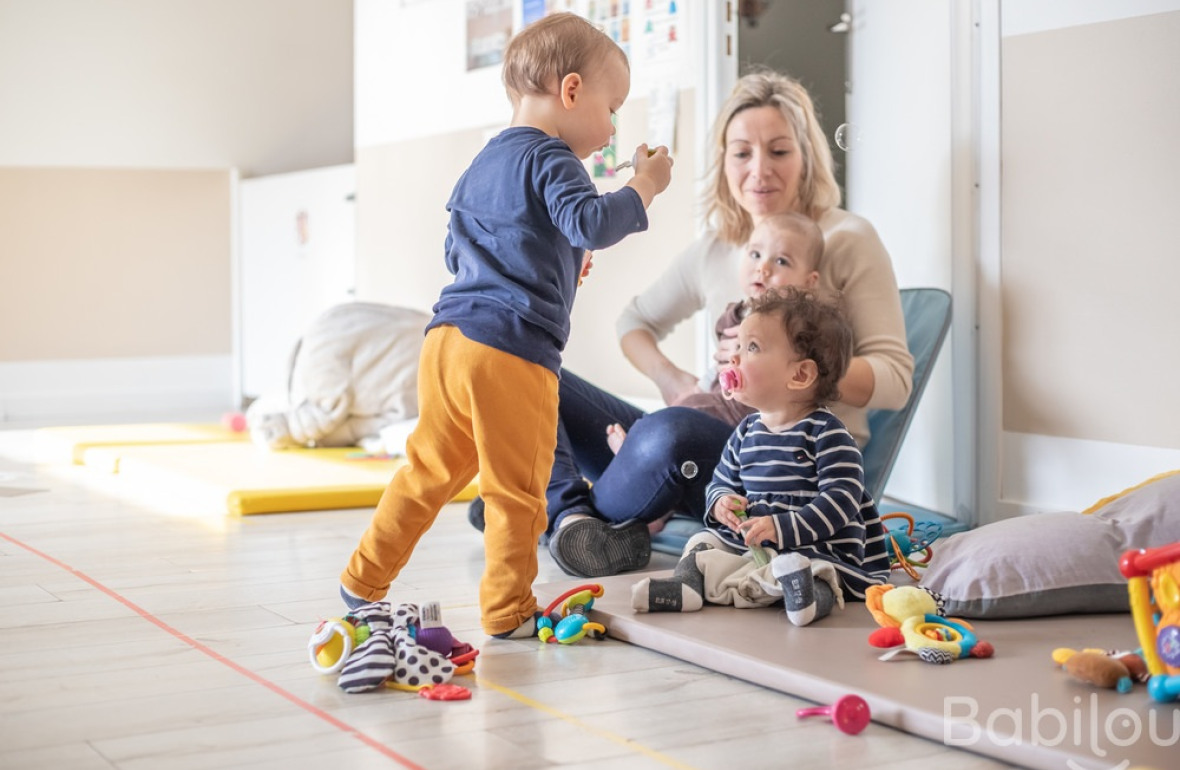 Une professionnelle en crèche Babilou avec deux enfants