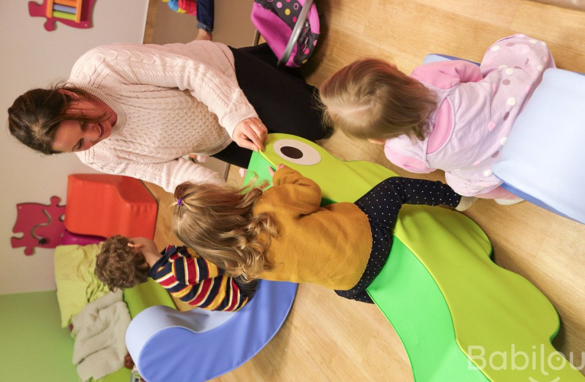 Une professionnelle en crèche jouant avec deux enfants