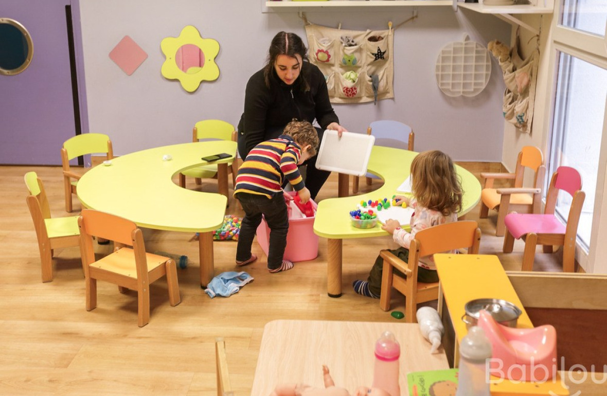 Une professionnelle en crèche jouant avec deux enfants