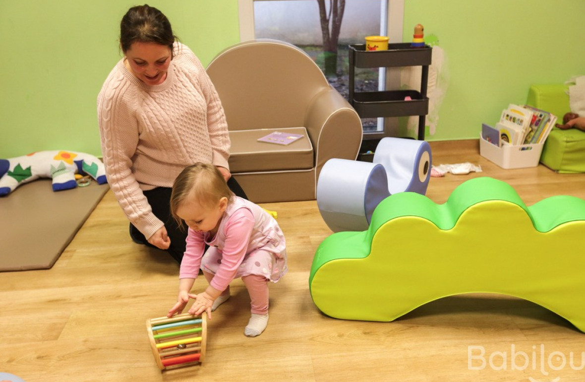 Une professionnelle en crèche Babilou qui joue avec une enfant