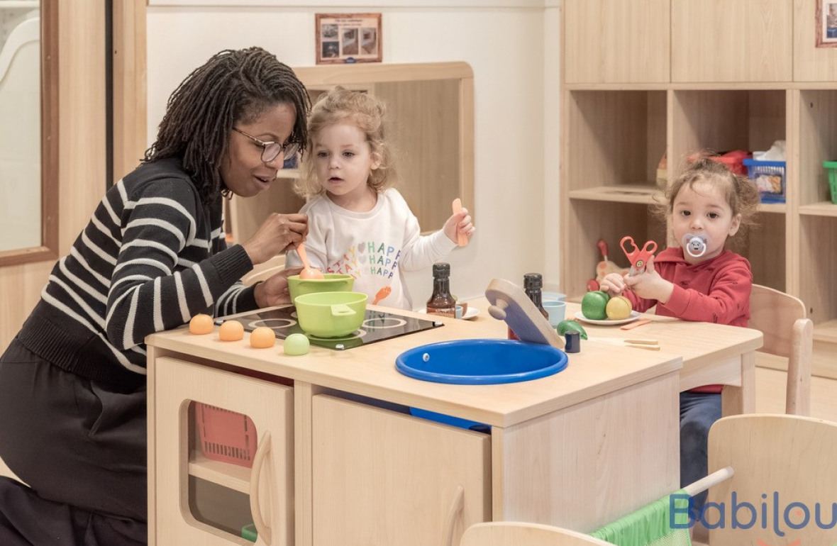 Une pro en crèche jouant avec deux enfants