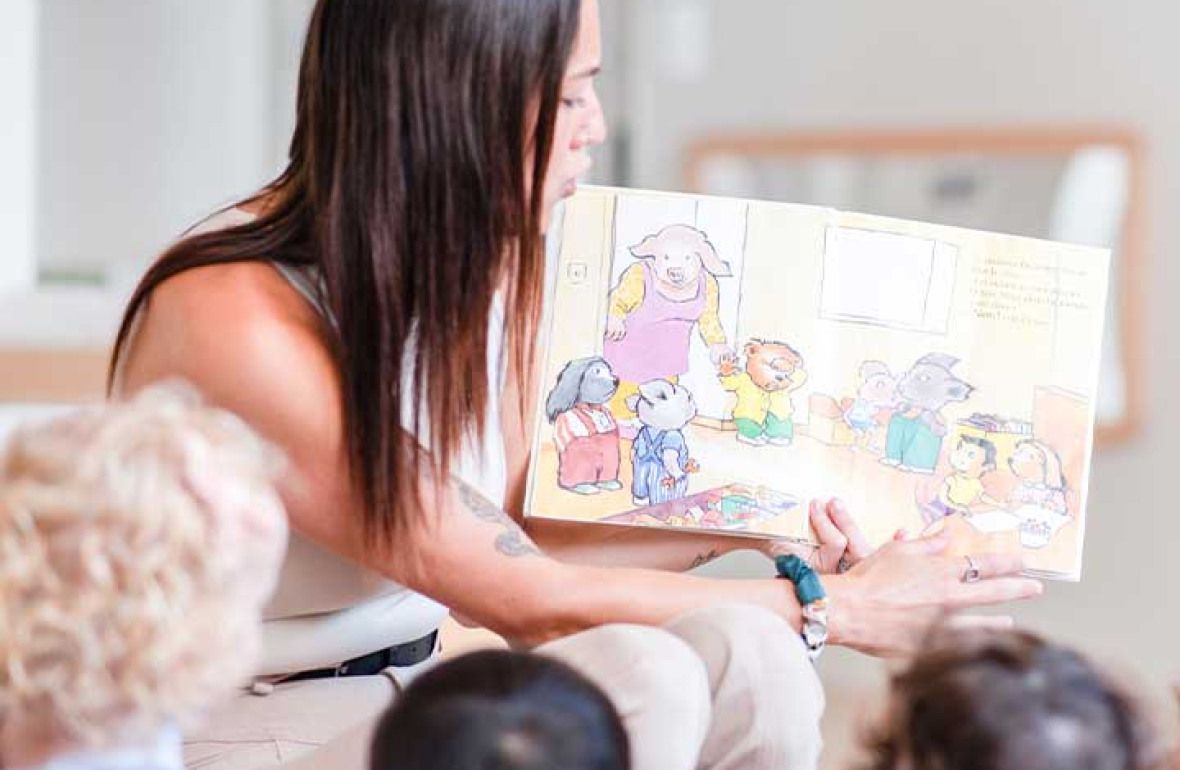 Professionnelle en crèche entourée d'enfant rigolant