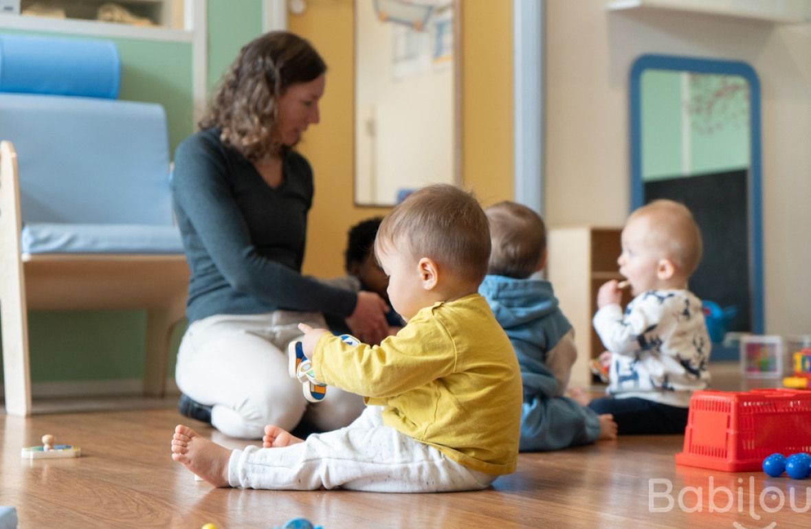 Une pro en crèche en interaction avec un groupe d'enfants