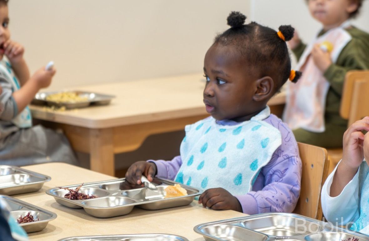 Un groupe d'enfants en crèche, entrain de manger