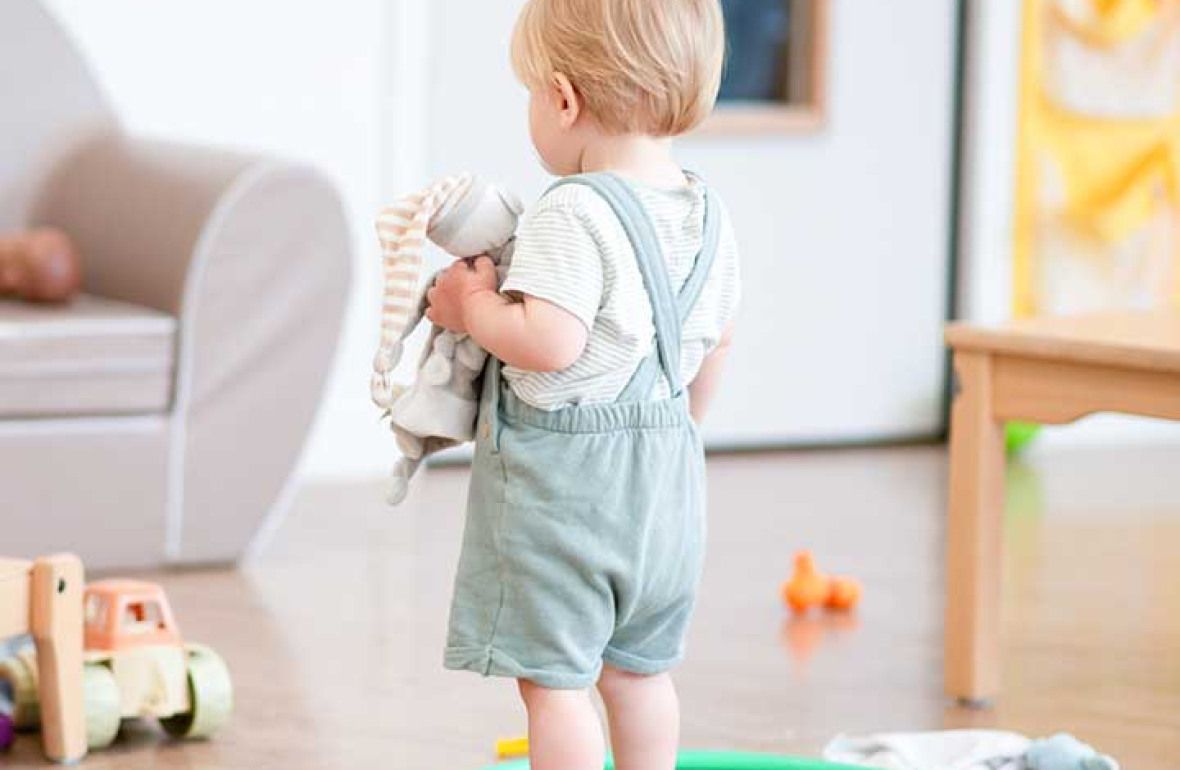 Enfant debout de dos tenant un lapin en peluche au sein d'une crèche Babilou