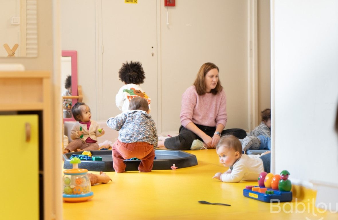 Une pro en crèche en interaction avec un groupe d'enfants