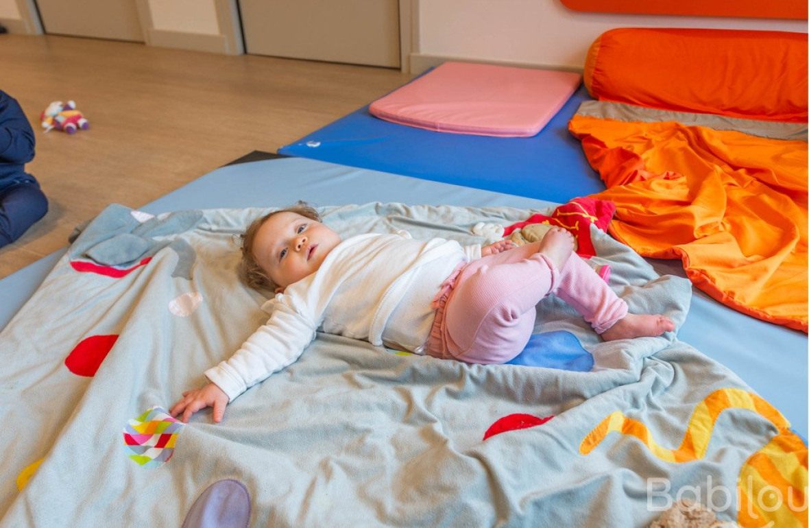 Une enfant en crèche Babilou allongé