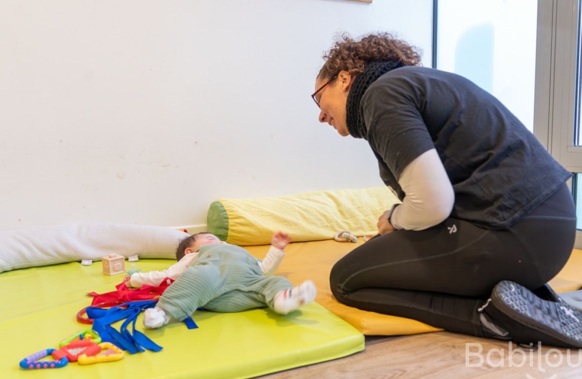 Une pro en crèche en interaction avec un bébé