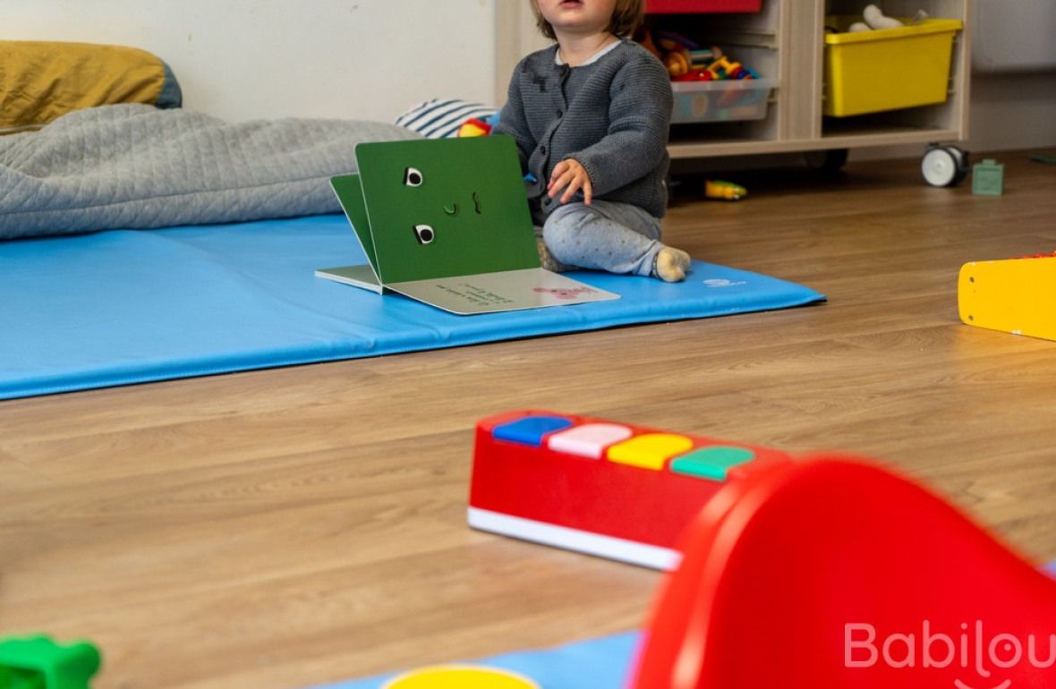 Un enfant en crèche qui lit
