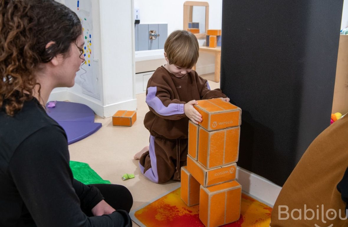 Une pro et un enfant en crèche en interaction 